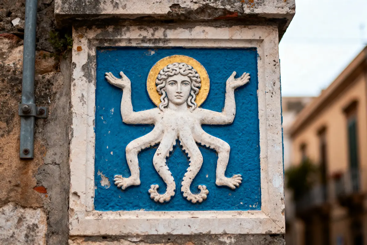 Bas-relief représentant une figure mythologique avec trois jambes et deux bras sur fond bleu et cadre blanc.