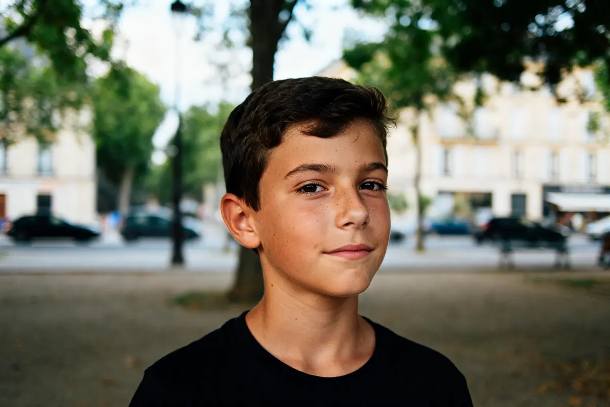 Jeune garçon au sourire calme dans un parc ensoleillé, prénom garçon doux et calme